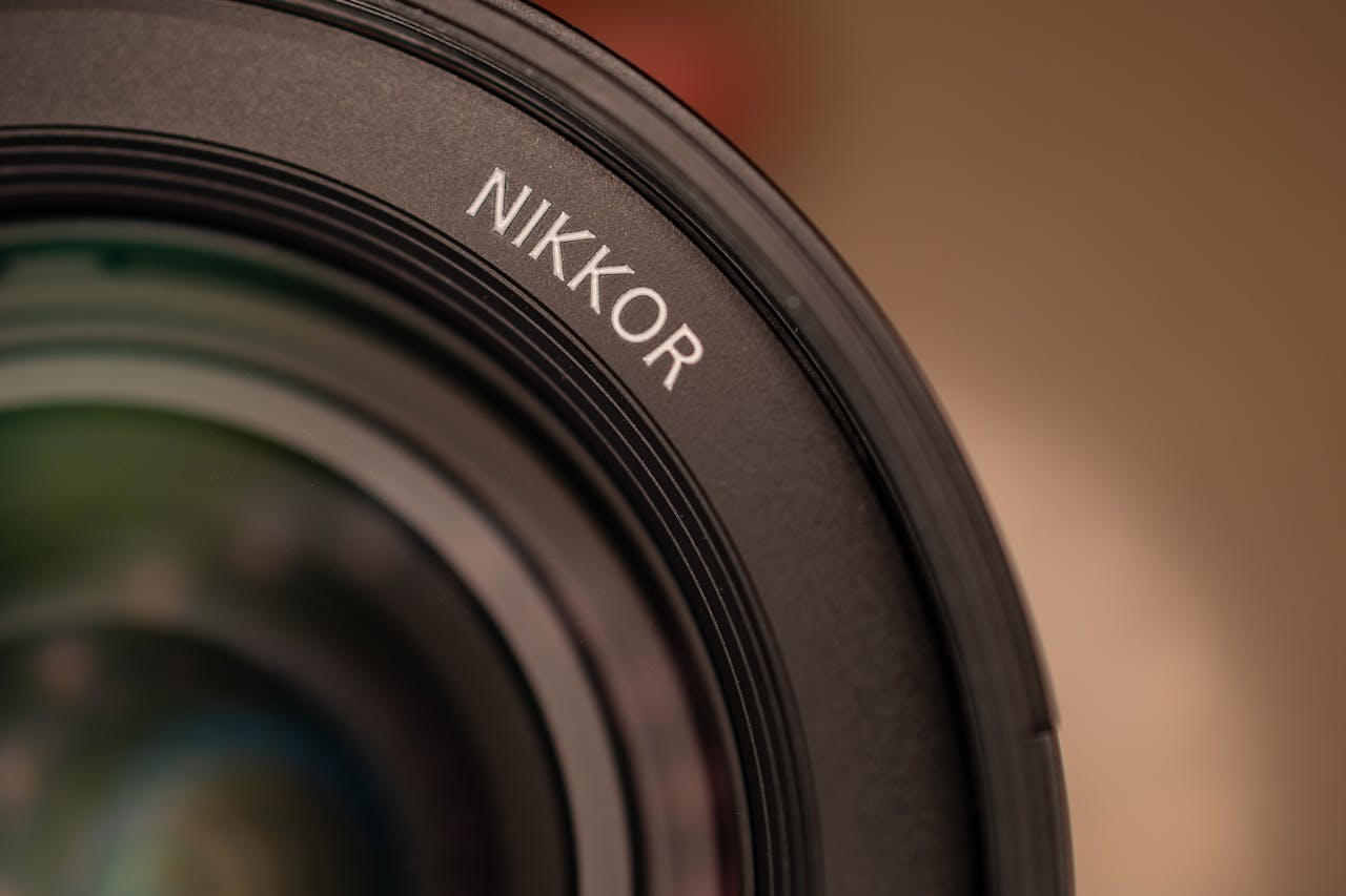 Detailed macro photo of camera lens edge showcasing NIKKOR branding and lens details.