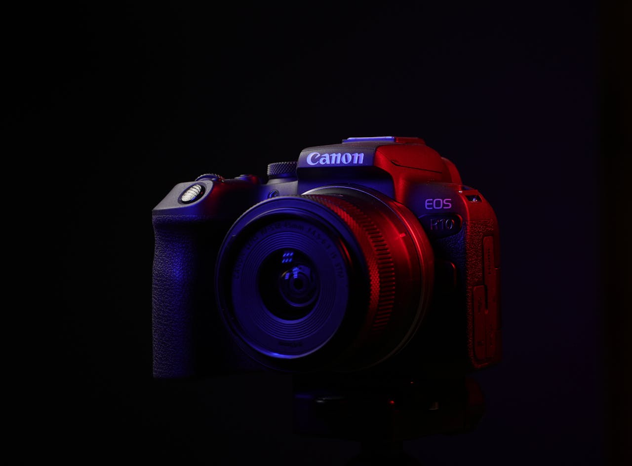 Close-up view of a DSLR camera with dramatic lighting on a black background.